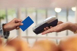 a customer about to swipe their credit card on a terminal after the merchant found out what is interchange plus pricing