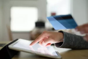 A customer putting card information on a tablet after being told what is recurring payment