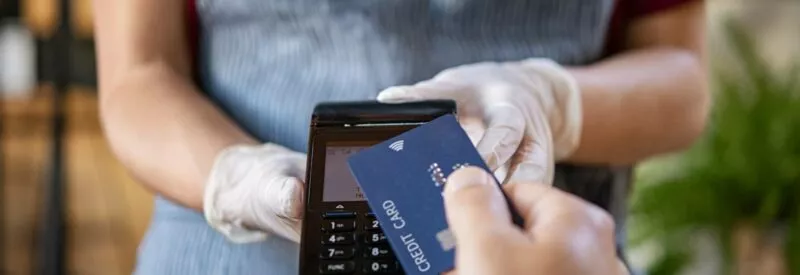 a person holding terminal to do credit card processing with a customer's credit card