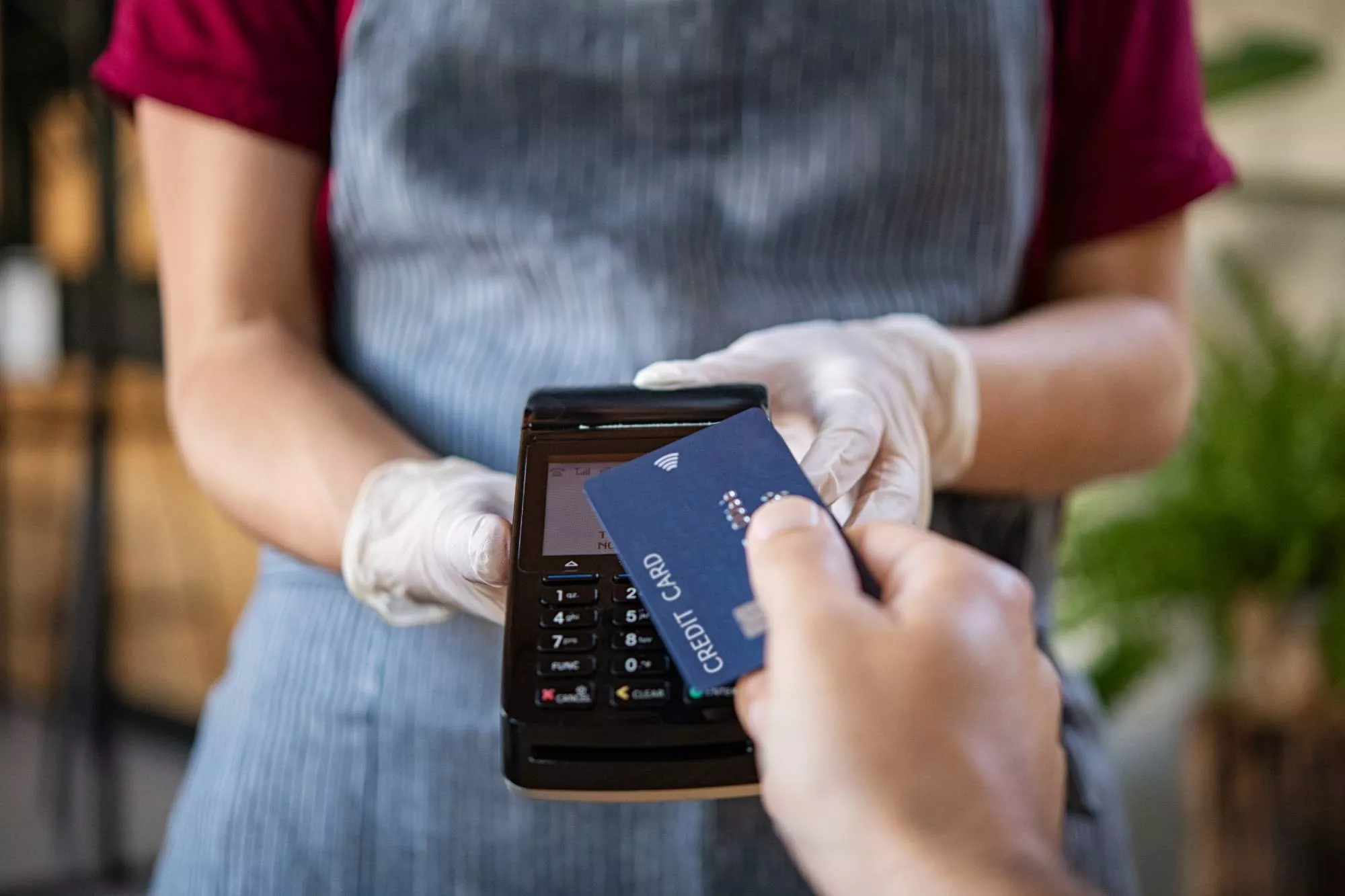 a person holding terminal to do credit card processing with a customer's credit card
