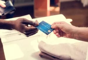 a customer giving their credit card to a business owner to update information on the updater service 