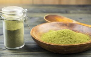 powdered kratom in a bowl and a jar on a table