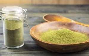 powdered kratom in a bowl and a jar on a table