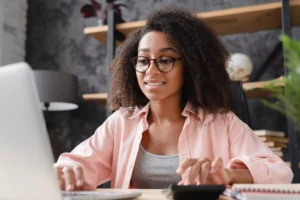 Woman calculating chargeback ratio on computer 