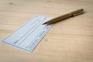 a blank check on a wooden table to later be used to verify a check 
