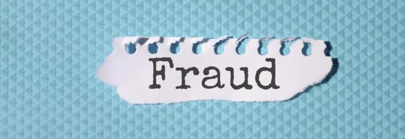 a torn paper on a blue background that has fraud on it to represent a fake check