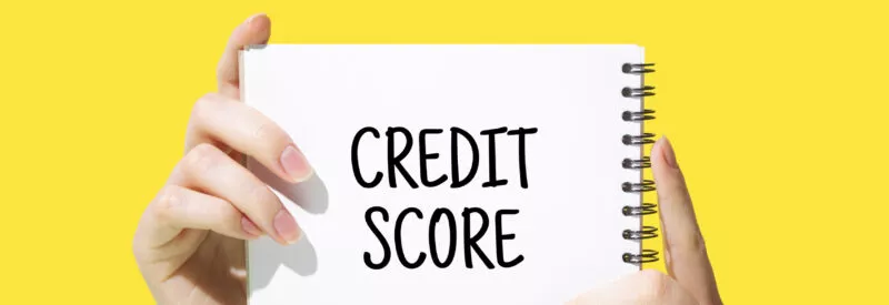 business credit score written on a notepad with a black marker against a bright yellow background