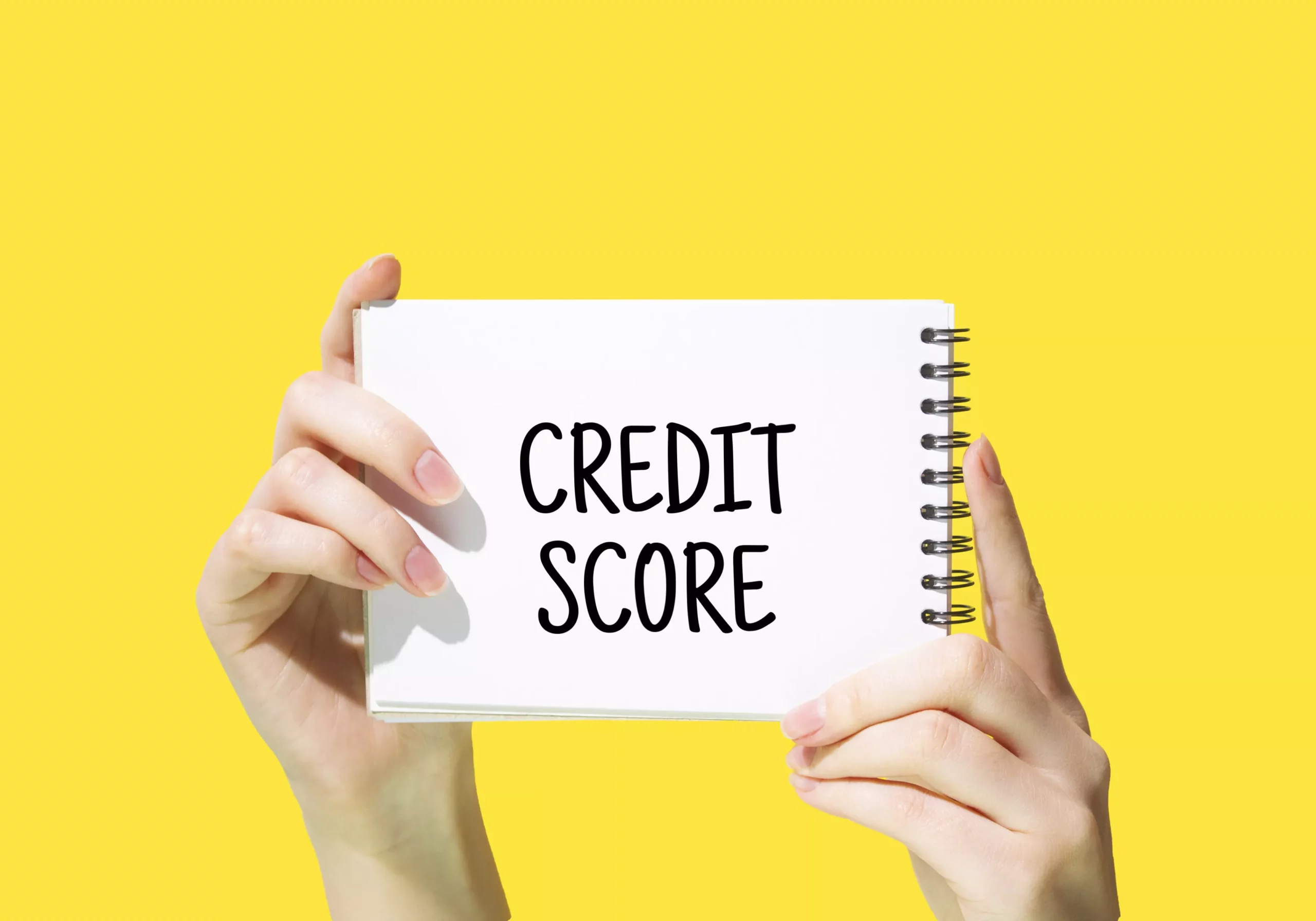 business credit score written on a notepad with a black marker against a bright yellow background