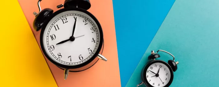 Two clocks on multi-colored backdrop