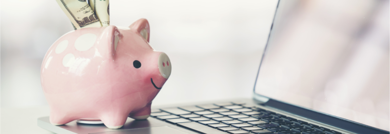 Picture of a piggy bank with cash in it on top of a computer to represent a provisional credit supplied by an issuing bank
