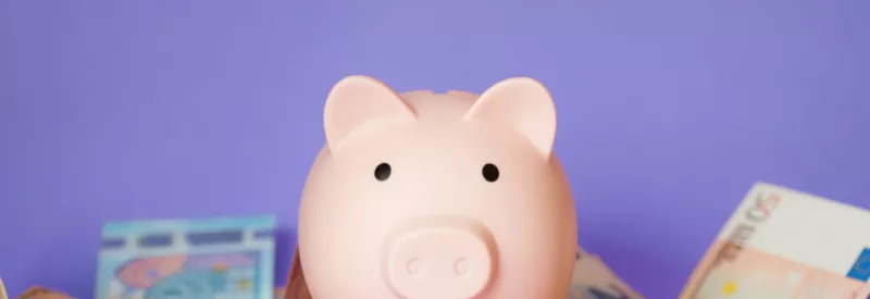 A piggy bank with money against a purple background to represent an upfront reserve as a savings account
