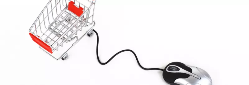 A shopping cart attached to a computer mouse moving to a computer with a bigcommerce gateway.