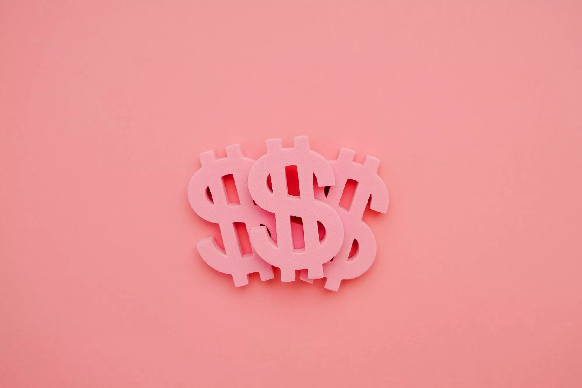 Pink dollar sign magnets against a pink background to represent gateway fees.