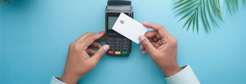 A credit card terminal with a person swiping a card at a business wondering how to accept payments without a merchant account.