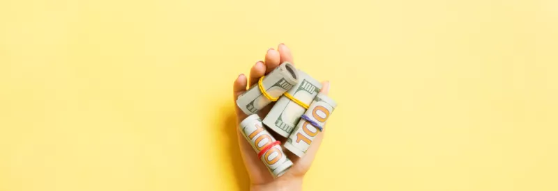 merchant account money on hold in a hand against a yellow background