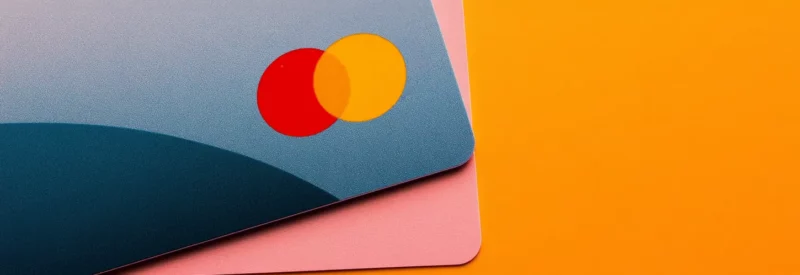 Close-up of layered credit cards in modern colors with the Mastercard logo prominent