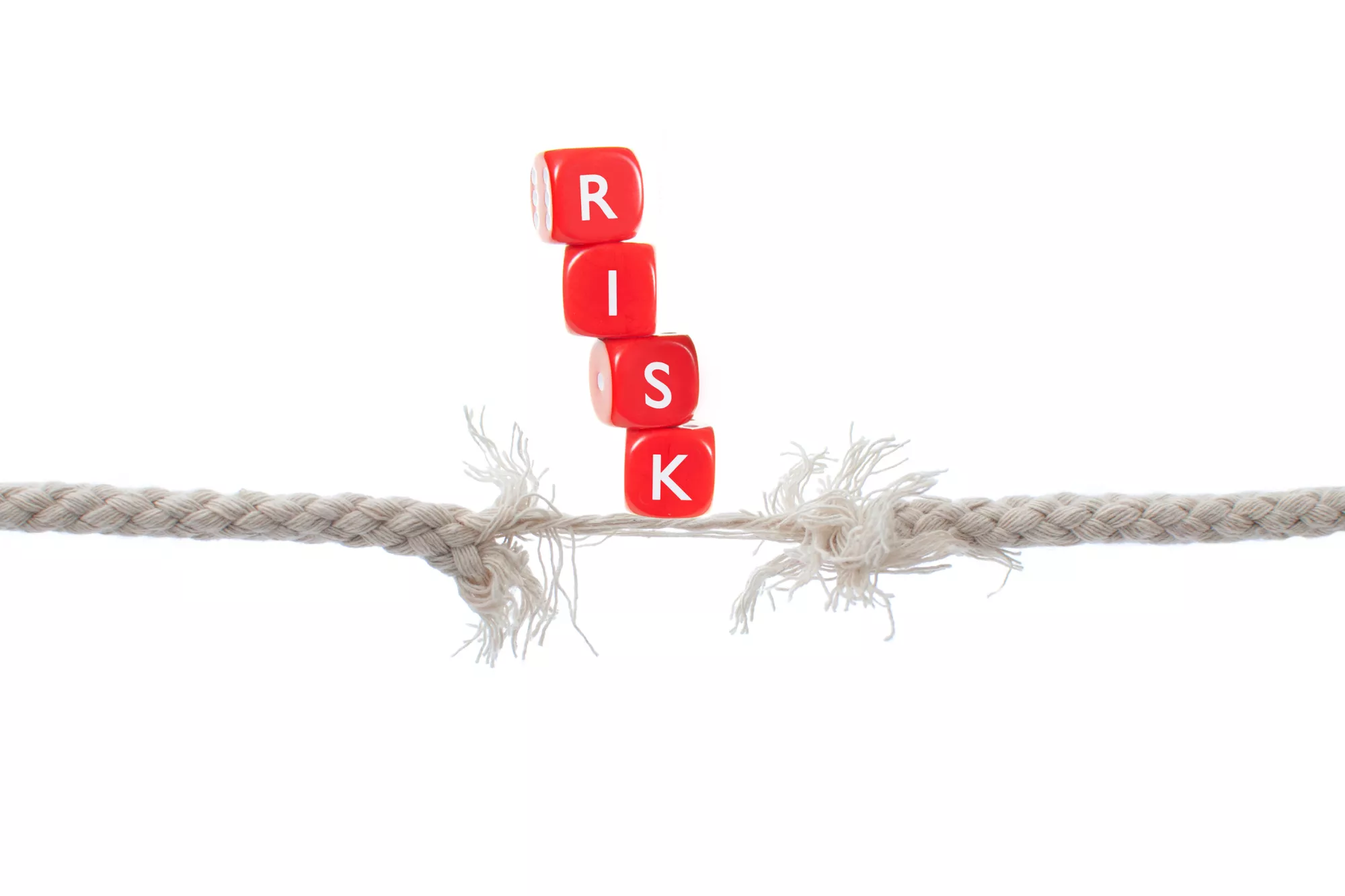 Two ropes balancing red blocks that spell out 'risk' to represent visa high-risk mcc codes.