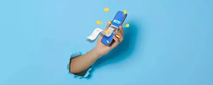 A hand holding a cell phone while breaking out of a blue wall