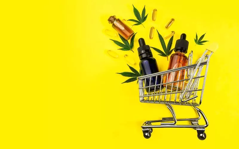 a bright yellow background with CBD products in a cart ready to be sold after the passing of Texas CBD laws