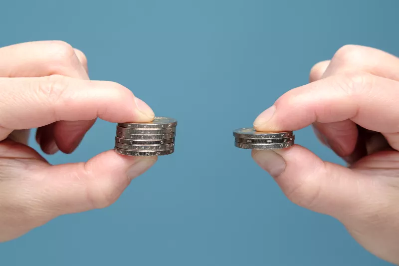 Two hands holding coins representing the comparison of shopify vs stripe