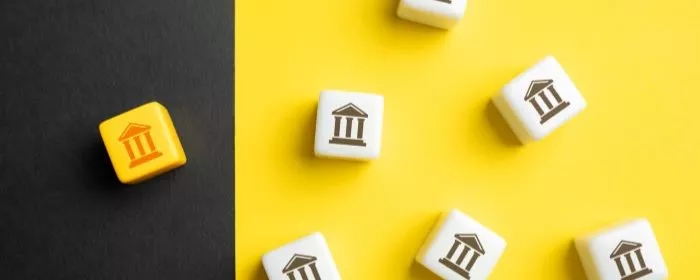 Wooden blocks on a black and yellow platform put by a merchant searching how to delete a zelle account.