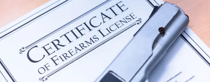An FFL license with a gun laying on it.
