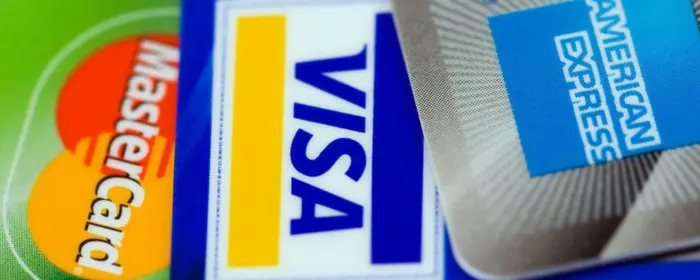 A Visa, Mastercard and AmEx card showcasing the Visa and Mastercard Interchange Settlement.