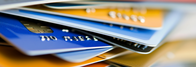 A close-up stack of colorful credit cards with embossed numbers and chip details, symbolizing various business credit card options.