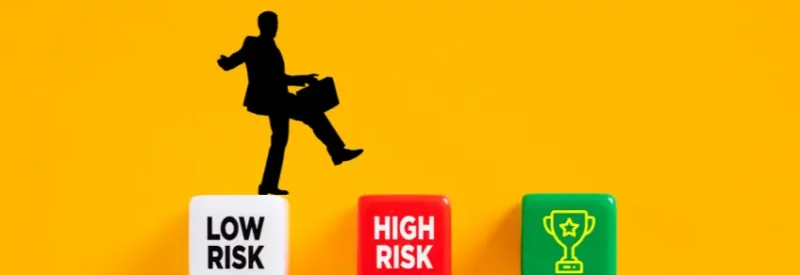 A silhouette of a man carrying a briefcase steps on a low-risk cube to get a high-risk merchant account