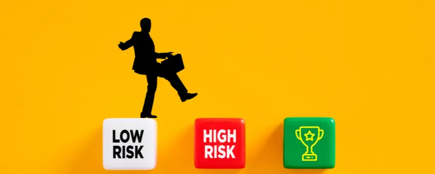 A silhouette of a man carrying a briefcase steps on a low-risk cube to get a high-risk merchant account