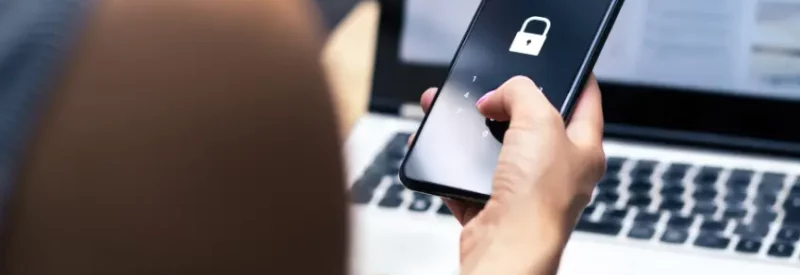 A person with a phone using ecommerce fraud prevention with security measures.