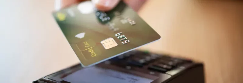 Merchant tapping credit card for zero-cost processing transaction.