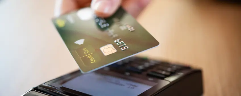 Merchant tapping credit card for zero-cost processing transaction.