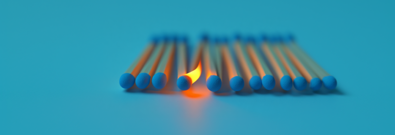 Blue match sticks laid horizontally with one lit