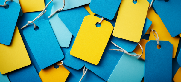 Scattered blue and yellow blank product label tags with strings.
