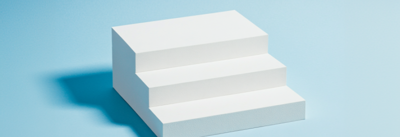 White minimalist stairs with three steps on a light blue background.