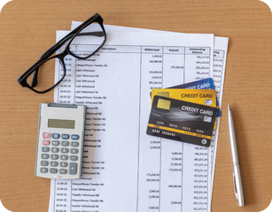 high-risk merchant statement, calculator, glasses, and credit cards sitting on table